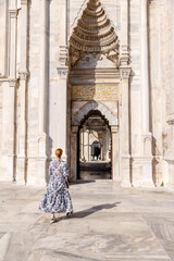 Naklejka premium Istanbul, Turkey - July 22,2023: A blonde woman walking amongst the architecture of the Nuruosmaniye Mosque in Istanbul 