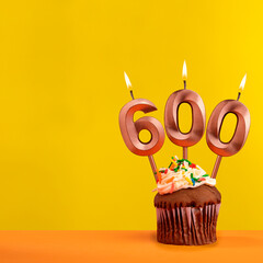 Number 600 anniversary candle - Celebration on yellow background