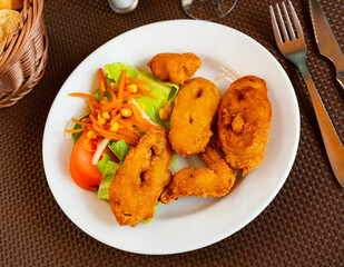 Appetizing andalusian fried squid rings served on plate in restaurant