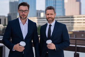 Business success men outdoor. Two businessmen on business successful meeting in city. Successful partnership. Men on city street outdoor. Business strategy. Business teams success.