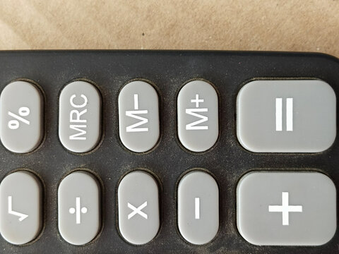 closeup single black digital calculator isolated on wheatish background, electronic office supplies for calculating the numbers in business finance or mathematics education.