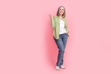 Naklejka premium Full length photo of gorgeous positive lady wear green trendy outfit recommend buy clothes special offer isolated on pink color background