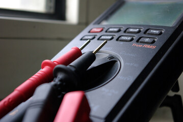 Close up photo of an electrical and electronics measurement device with black and red probes used...