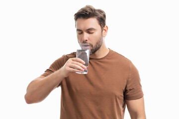 Man drinking fresh water. Male model holds glass of clear water. Healthy lifestyle, health care. Mineral water refreshment, daily dose of clean aqua, dehydration. Portrait of man drinking water.