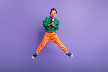 Photo of cheerful crazy boy wear green stylish clothes speak microphone have fun entertainment...