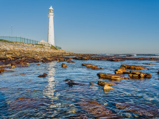 Slangkop Lighthouse and its reflection in the sea water during a clear afternoon, Kommetjie, Cape Town, South Africa © Arnold