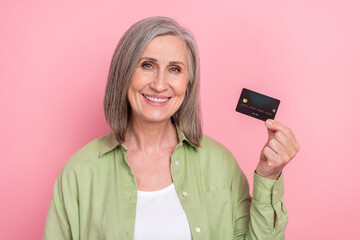 Photo of pensioner woman wearing khaki shirt holding black premium terms mastercard plastic...