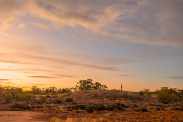 A lone figure of a man on the horizon in the remote country of Australia at sunset in Currawinya National Park.