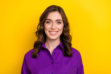 Fototapeta premium Portrait of adorable cute gorgeous girl with curly hairdo wear violet blouse toothy smiling at camera isolated on yellow background