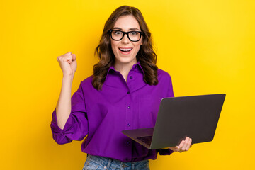 Photo of smart toothy beaming rich woman with curly hairdo dressed purple shirt hold bunch of dollars isolated on yellow background