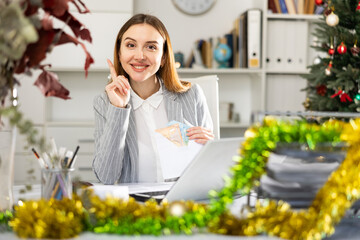 Portrait of a happy female manager with money in an envelope - christmas present