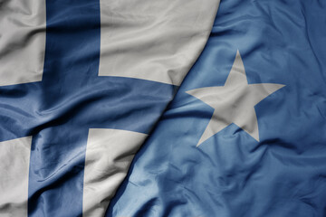 big waving national colorful flag of finland and national flag of somalia .