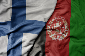 big waving national colorful flag of finland and national flag of afghanistan .
