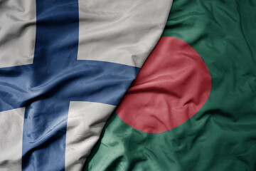 big waving national colorful flag of finland and national flag of bangladesh .