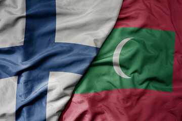 big waving national colorful flag of finland and national flag of maldives .