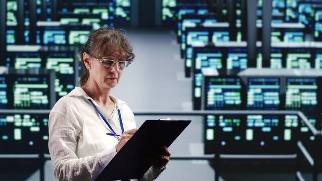 Knowledgeable serviceman in data center equipped to handle complex computational operations, doing regular upgrades to server units, increasing processing power to prevent hazards