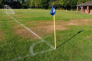 A corner flag and pitch markings at the corner of a football pitch in England, UK