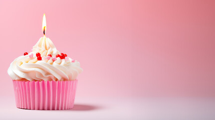 Cupcake birthday cake with a candle on pastel pink background with copy space	