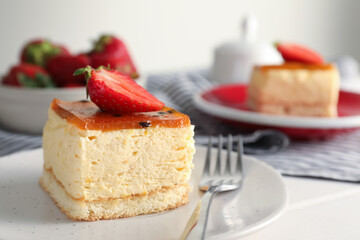Piece of cheesecake with strawberry and fork on table, closeup with space for text