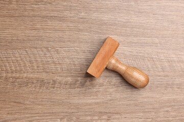 One stamp tool on wooden table, top view. Space for text