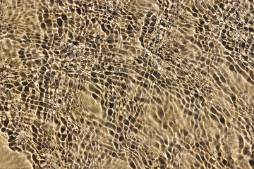 rippled water surface over a sand beach