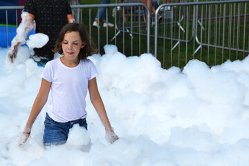 happy girl with foam on her head, in wet clothes at a foam party, in wet clothes at a foam party