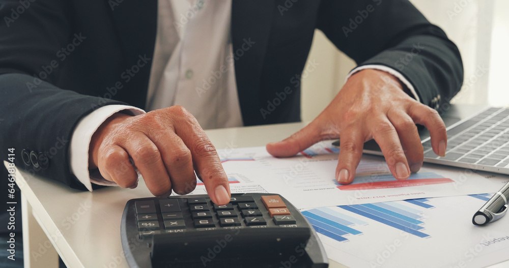 Wall mural Asian businessman hands calculating number, graph, chart audit planning accountancy on business report. Asian professional Business man hands using calculator counting tax financial bill.