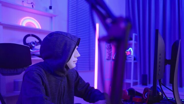 Short of computer hacker wearing white mask stealing data from a laptop. 