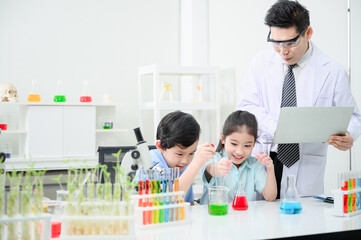 Fototapeta premium Male and female students and teachers work together to study test tubes in the studio. Study with fun
