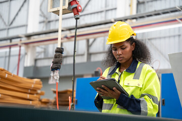 Female engineer using tablet in factory. She looking product or data in tablet at factory.