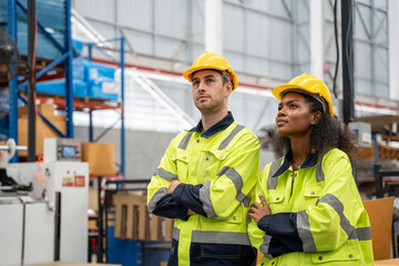 Portrait of team engineer standing at factory together. They checking machine in factory.