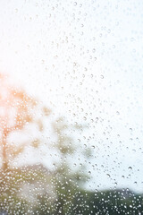 blur background with sunlight on rainy day, water droplet on mirror