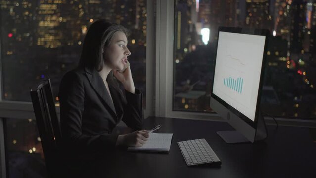 Young Confident Woman Working in Modern Office on Computer Desk At Night