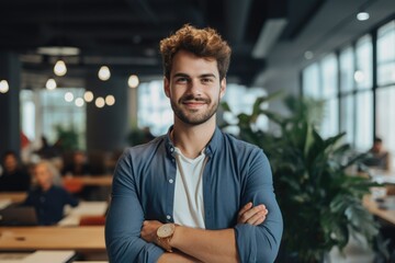Smiling portrait of a happy young caucasian man working for a modern startup company in a business office