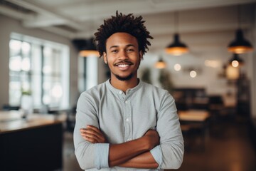 Smiling portrait of a happy young african american man working in a modern startup company in a business office