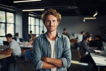 Smiling portrait of a happy young caucasian man working for a modern startup company in a business office