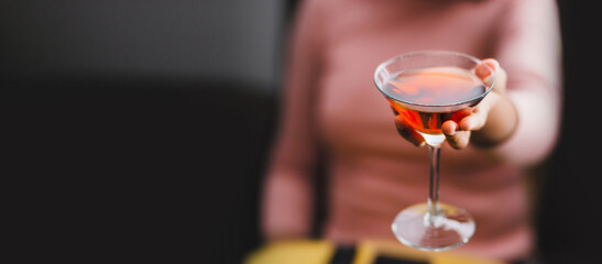 Young woman holding a wine glass in close-up. Celebration and social gatherings concept. Selective focus. Space for text.