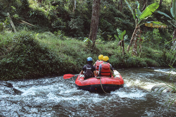 Group of teenagers are rafting on the river, extreme and fun sport at tourist attraction