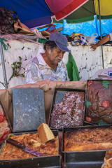 Old latino man eating sweet bread in El Salvador, typical food of El Salvador. With sweet bread in the foreground, seeing his hands