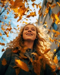 Naklejka na ściany i meble flying autumn leaves .low angle photo, young 20 years old woman, vibrant