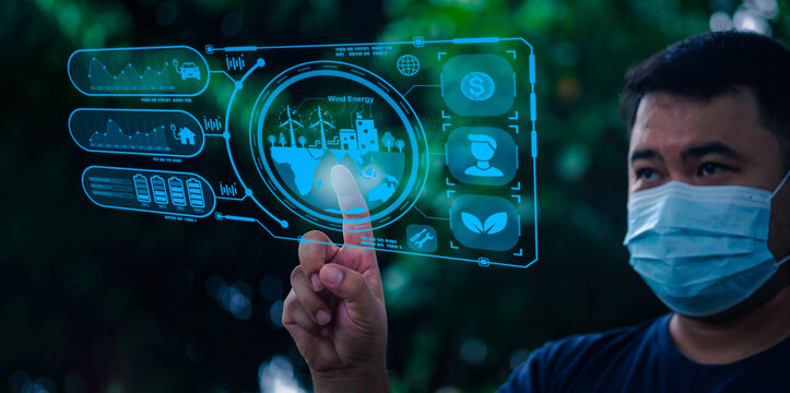 Young man finger touches hud hologram, glowing ecological icons and global connection. Concept of green energy and technology. Concept of renewable resources, technology and planet protection.