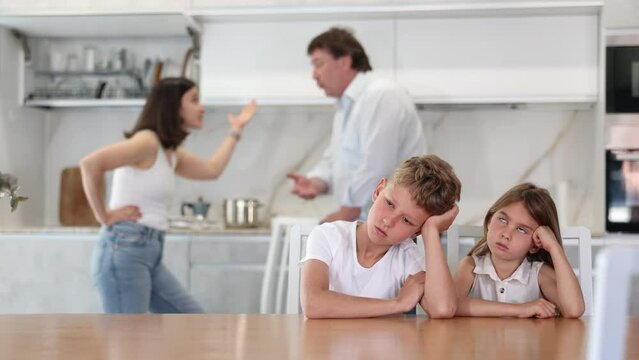 Kids feels upset while parents quarrel at background. Sad little girl and boy frustrated with psychological problem caused by mom and dad arguing, family conflicts or divorce impact on child concept
