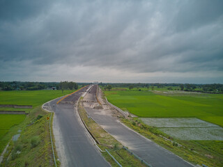 top aerial view of national highway through the agricultural field in India