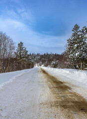 Walking on a snow-covered roadbed in a mountainous area, treated with a sand mixture from anti-skid.