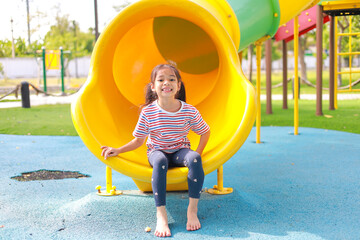 Little kid girl asian  while enjoying on the playground. Which increases the development and enhances outside the classroom learning skills concept.