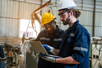 Team of engineers and technician using laptop checking and repair pressing metal machine at factory, Machine maintenance technician operation concept.