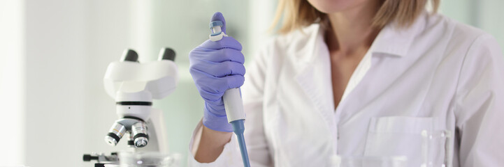 Woman scientist is working in scientific laboratory with test samples.