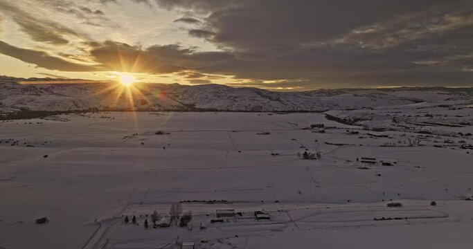 Oakley Utah Aerial v1 drone flyover village town capturing golden sunset sun shinning across pristine snow fields and beautiful mountainous landscape in winter - Shot with Mavic 3 Cine - February 2023