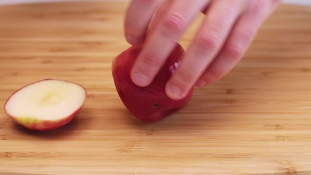 Close up of a red apple being cut into chunks