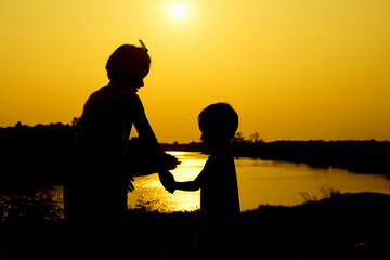 Silhouette of a family comprising a father, mother and two children happy family the sunset.Concept of friendly  - 646230021